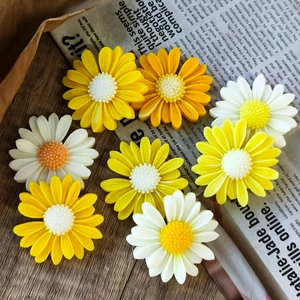 DIY daisy resin molds with white and yellow sunflower decorations on a wooden table
