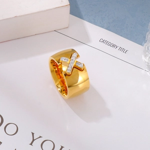 Macro detail of gold X-shaped ring with pavé-set cubic zirconia and polished finish