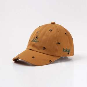 Detail of yellow cotton baseball cap featuring black polka dots and green embroidery