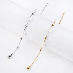 Dettaglio dei braccialetti placcati in oro e argento con perle d'acqua dolce e sfere