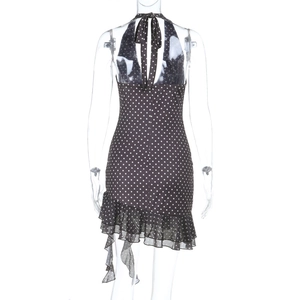 Détail d'une robe dos nu sombre à pois blancs avec dos ouvert et volants élégants