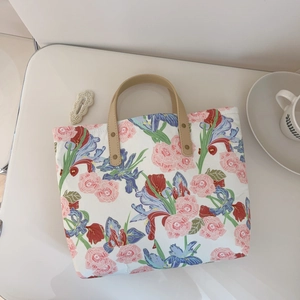 Detailed top view of a sturdy floral tote bag with pink roses and blue iris patterns