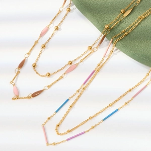 Detail of gold chain necklace with colorful enamel heart charms and wheat square pendants