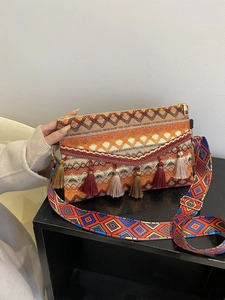 Close-up of bohemian woven bag featuring colorful tassels and ethnic geometric patterns