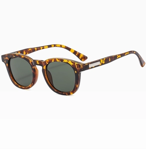Detail view of round tortoise shell sunglasses with metal inlay on the temple arms