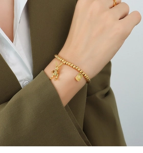 Nahaufnahme eines goldenen Hasen-Armbands mit Perlen am Handgelenk eines Models