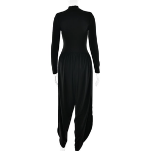 Detail of black long sleeve jumpsuit featuring wide-leg trousers on a mannequin