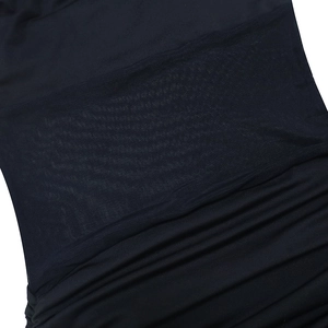 Detail of black irregular slim dress featuring mesh paneling and ruching textures