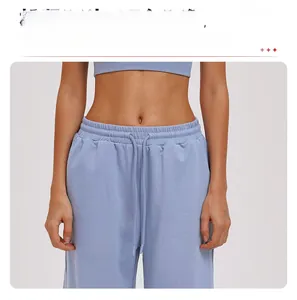 Detail of light blue sports sweatpants featuring elastic waist and matching drawstrings