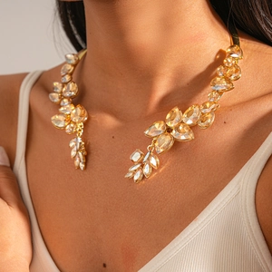 Detailed view of champagne and clear leaf crystals on a luxury golden choker necklace