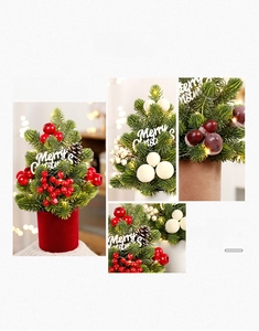 Detail of mini Christmas tree with LED lights, red berries, and natural pinecones