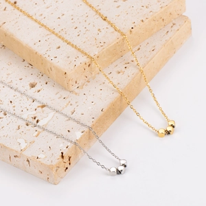 Chic gold and silver stainless steel necklace featuring three square cube pendants on stone