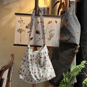 Close-up of artistic cotton canvas bag featuring colorful dog prints on a wooden rack