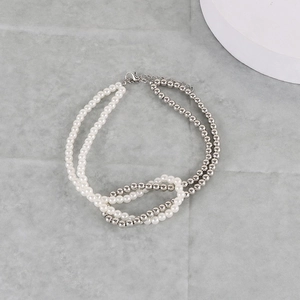 Close-up of double layer necklace featuring faux pearls and silver metal beads with lobster clasp
