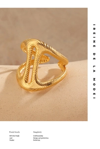 Detail of gold-plated open ring featuring hollow polygons and wavy vertical engraving