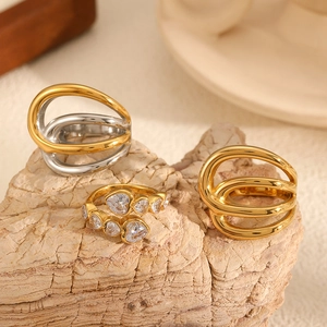 Three-piece gold and silver stainless steel geometric hollow rings on stone base