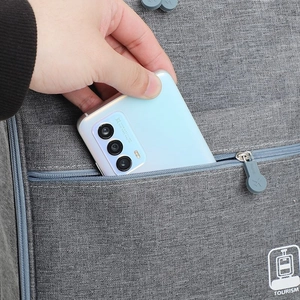 Grey travel shoe bag with three layers and luggage strap showing front pocket storage