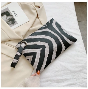 Close-up of stylish zebra print envelope clutch bag with matching wrist strap and PU leather