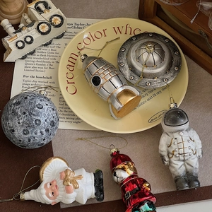 Close-up of retro astronaut and UFO ornaments with golden strings on a vintage plate
