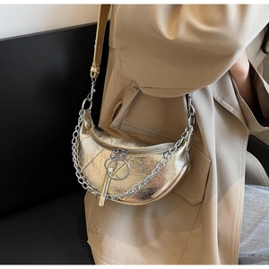 Detail of metallic gold crescent bag with round ring zipper and stylish chain strap