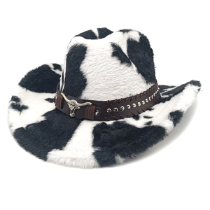 Detail of cow print cowboy hat featuring a brown leather band and silver bull emblem