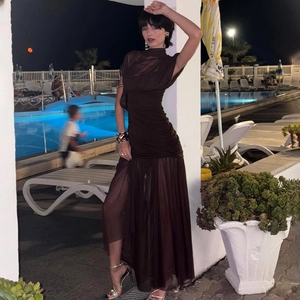 Détail du tissu en mesh marron transparent avec fronces sur une robe longue fendue sexy