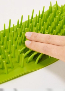 Close-up of soft green silicone bristles on a pet paw cleaner showing high flexibility