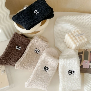 Detailed texture of thick coral fleece socks with cute cartoon eye embroidery for winter