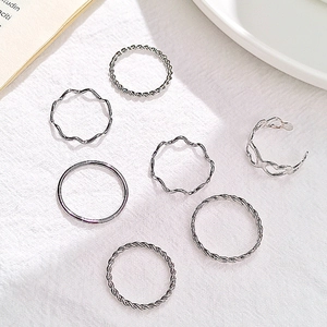 Detailed overhead view of 7-piece silver alloy rings including twist and heart designs
