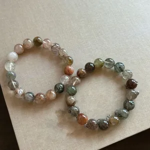 Macro shot of 8-10mm mixed natural quartz beads featuring rutilated and phantom crystal details