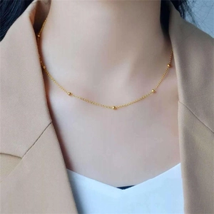 Elegant gold titanium steel choker necklace with small beads shown on a female model