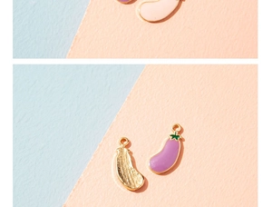 Macro detail of eggplant alloy pendant with purple enamel finish and golden back for DIY crafts
