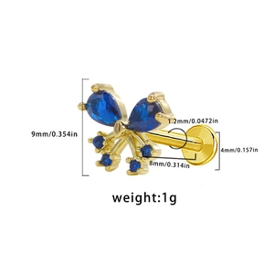 Macro detail of butterfly labret stud jewelry showing gold base and blue gemstones size