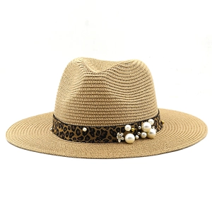 Dettaglio cappello Panama con fascia leopardata, perle e perline dorate sulla paglia
