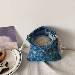 Sacchetto con coulisse in cotone e lino con motivo floreale mostrato con contenuto.
