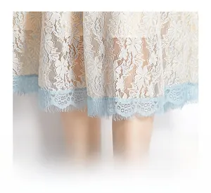 Close-up of elegant lace dress hem featuring light blue eyelash lace trim detail