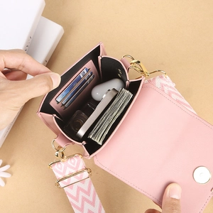 Pink mini crossbody phone bag with wide fabric strap and internal card slots