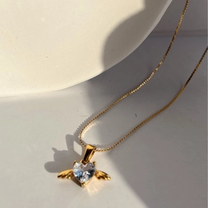 Elegant gold necklace featuring angel wing heart crystal pendant on a thin chain