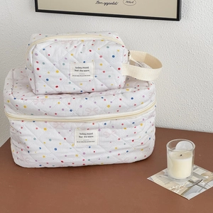 Detail of two-piece quilted pink polka dot makeup bags set with zipper and tags