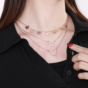 Three-layer rose gold butterfly necklace pendant shown on a professional model