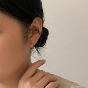 Side view of simple sterling silver zircon hoop earring worn by a model for a minimalist look