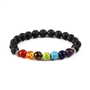 Detalle macro de cuentas de piedra de lava natural y gemas de chakra en la pulsera elástica