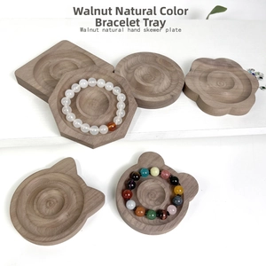 Flat lay of walnut wood jewelry display trays in various geometric and animal shapes