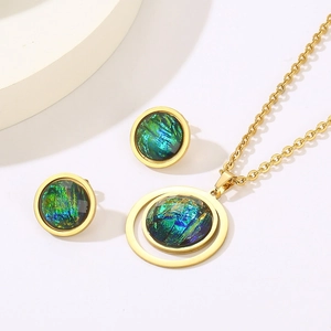 Detail of gold titanium steel jewelry set featuring teal resin heart-shaped pendants
