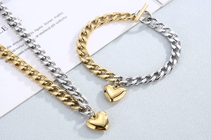 Detail of two-tone gold and silver Cuban chain set with heart pendant and OT toggle clasp