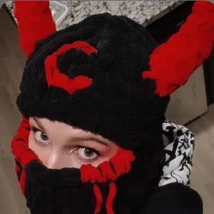 Detail of hand-knit black balaclava with red devil horns for Halloween costume party
