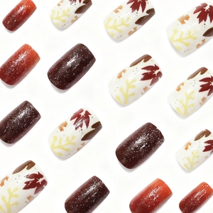 Autumn press-on nails featuring maple leaf patterns and warm glitter gradients in square shape