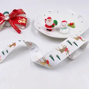 Christmas ribbon with gold reindeer and green pine trees on white ribbed fabric