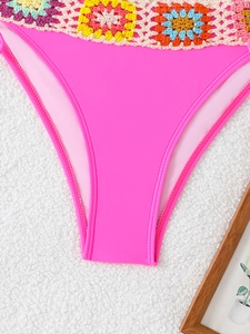 Detail of neon pink bikini bottom featuring colorful crochet floral waist embroidery