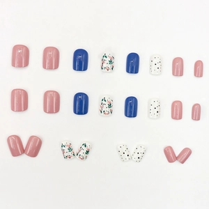 Pink and blue press-on nails set with floral patterns and polka dots on white background